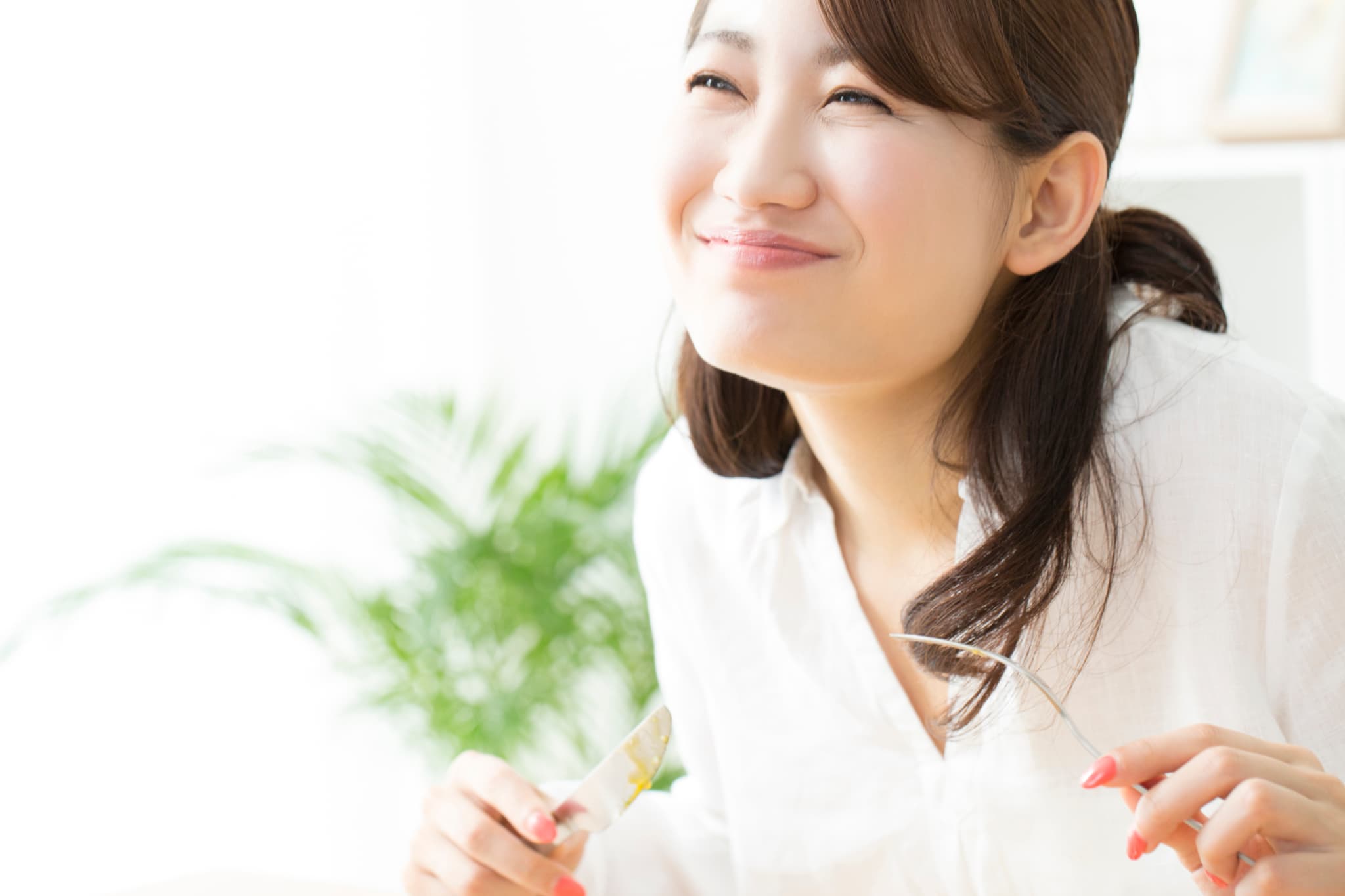 奥歯をインプラントにして食事を楽しむ女性