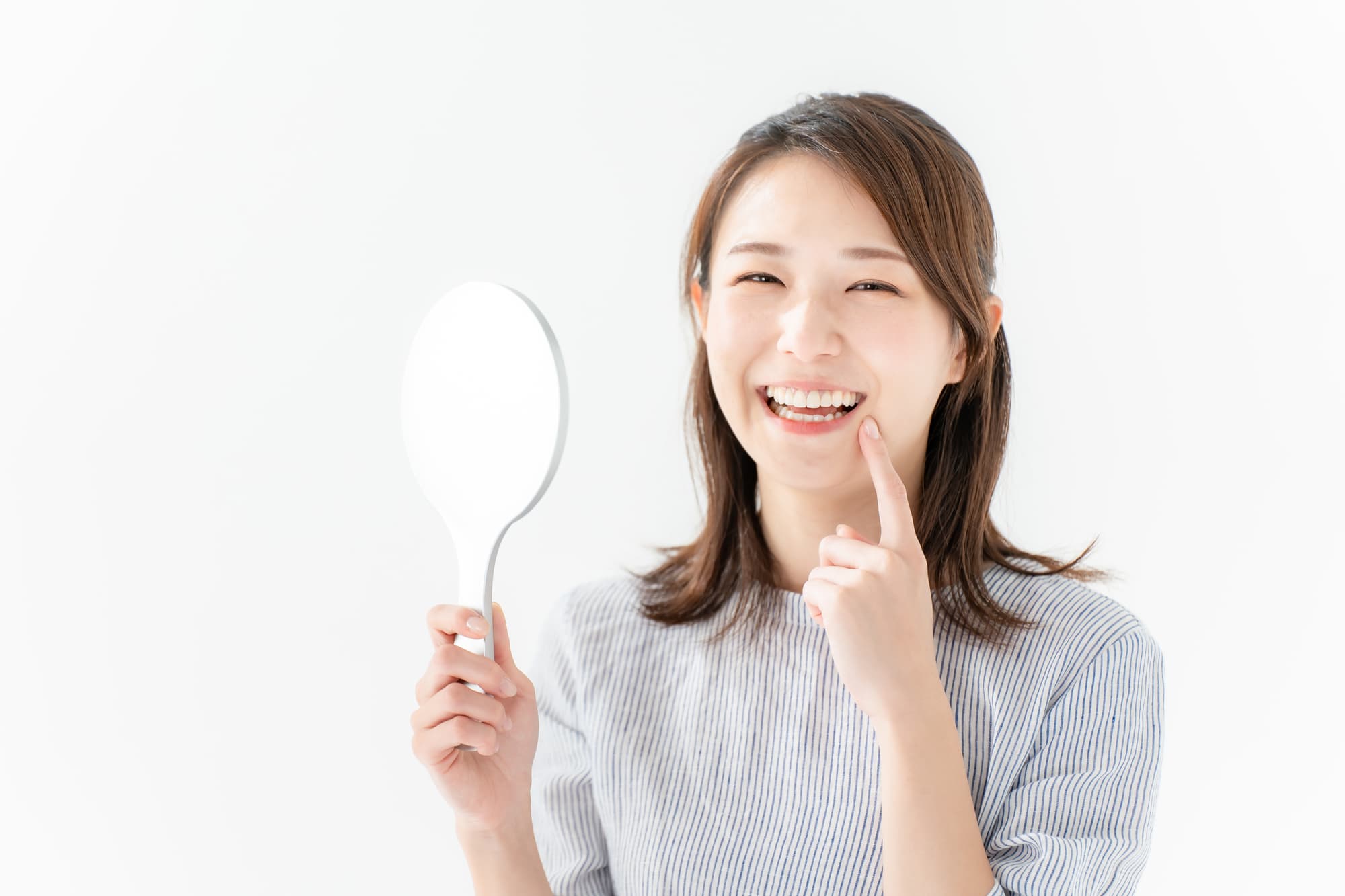 きれいになった歯並びを指さし嬉しそうな女性