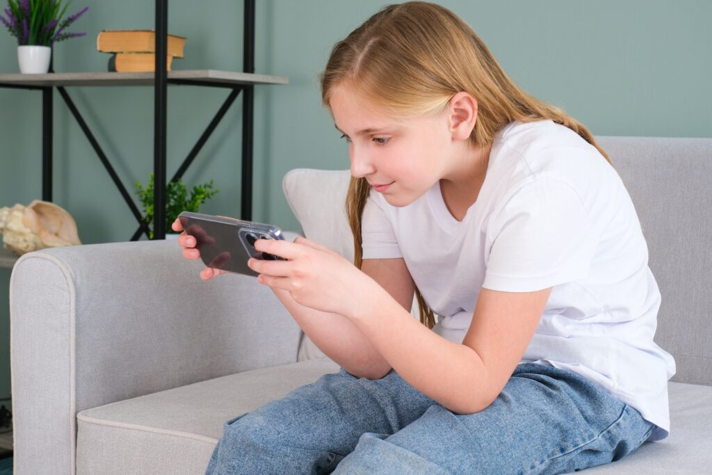 子どもが口呼吸をする原因となる悪い姿勢でゲームをしているこども
