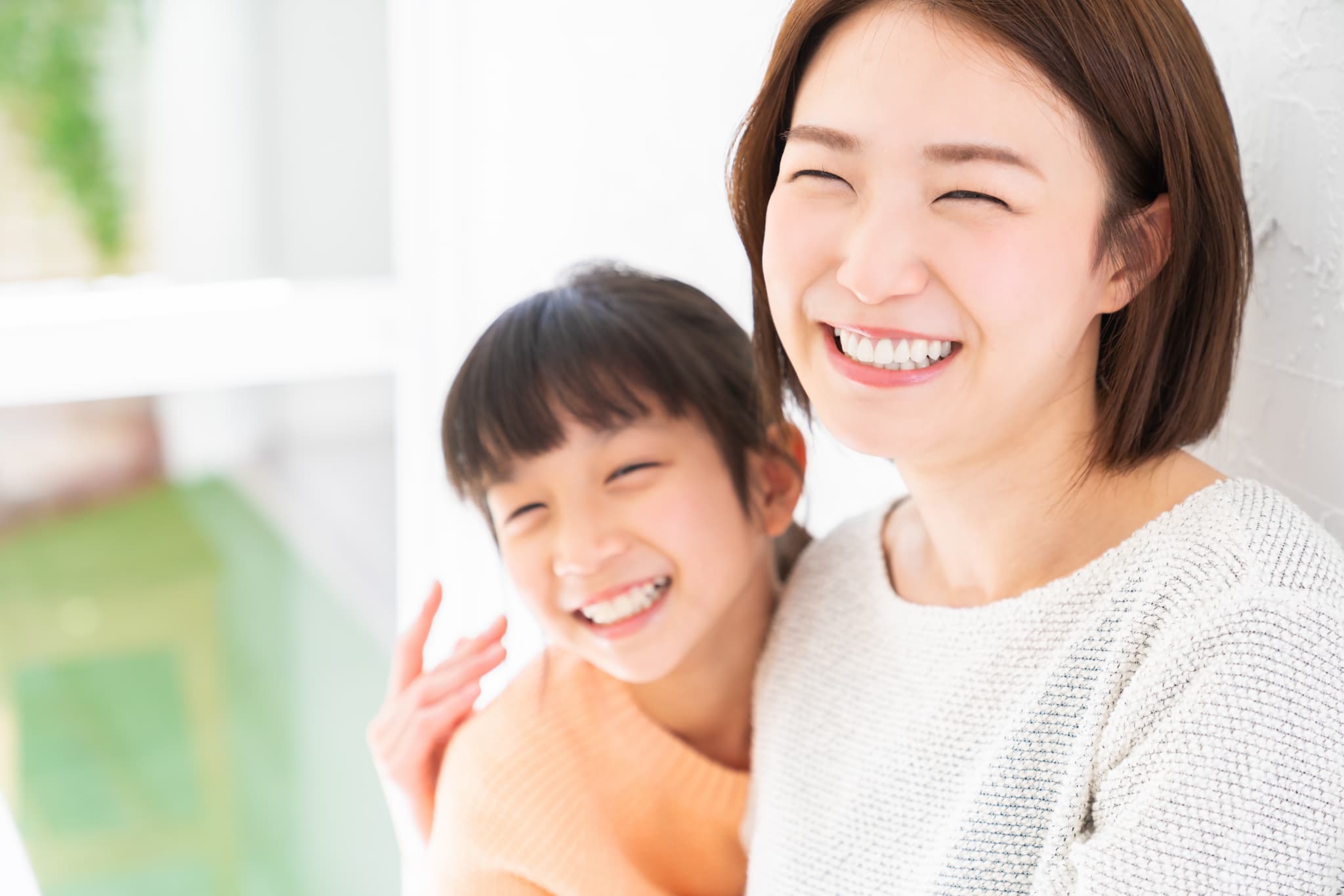 すきっ歯の治療をして整った歯並びになった子どもと笑顔の母親