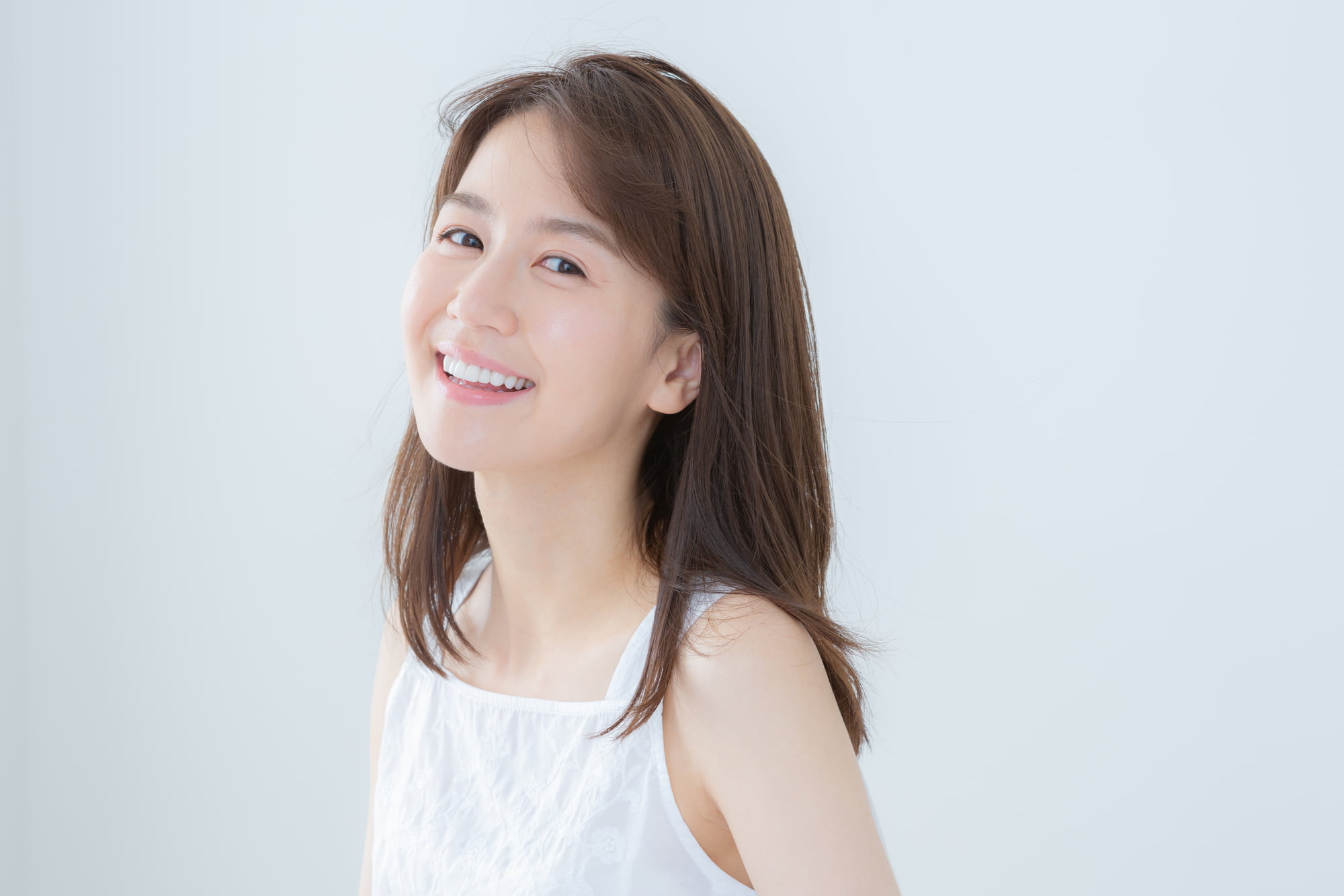 ホワイトニング治療に満足してほほ笑む女性